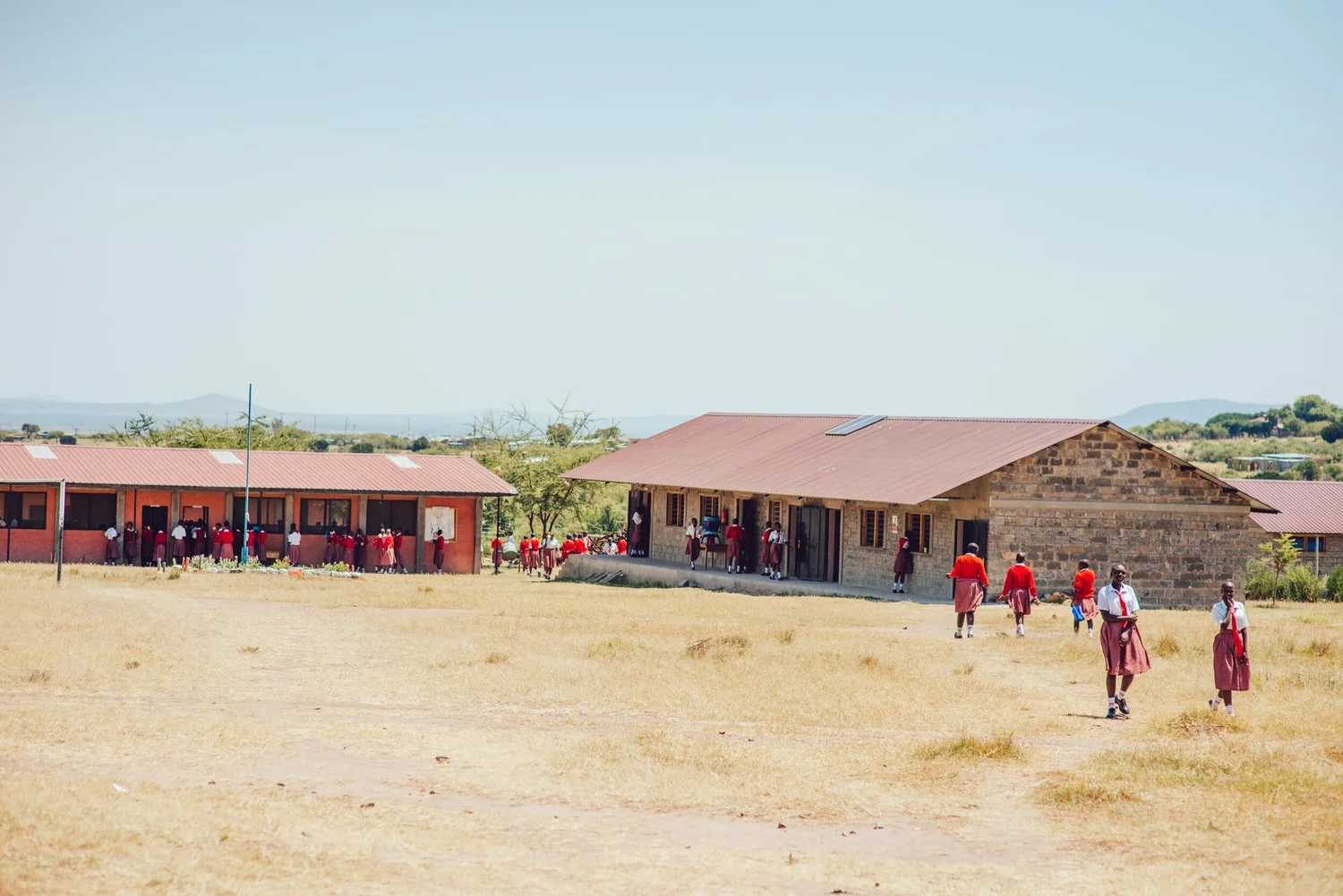 School building exterior with students in uniforms